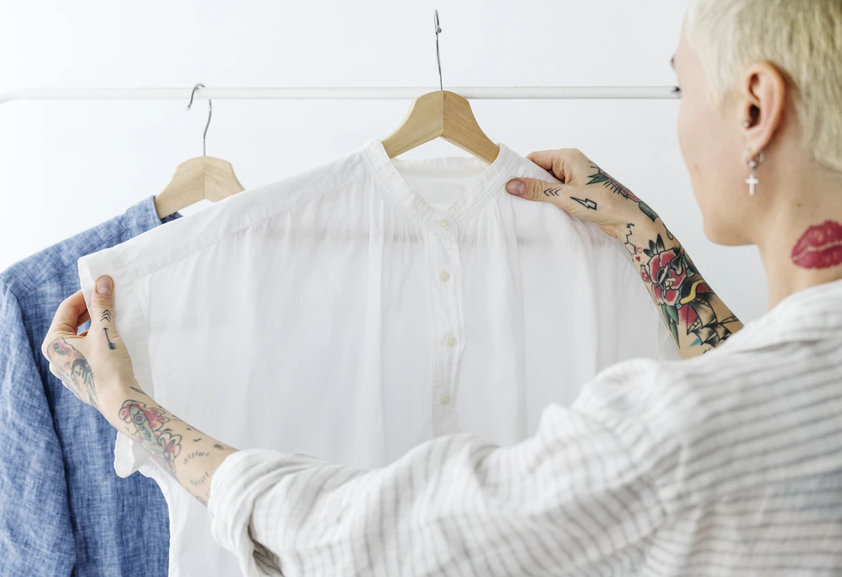 Une femme qui regarde un vêtement blanc sur un cintre